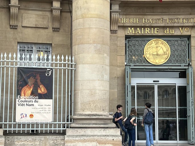 Art exhibition poster "Couleurs du Viet Nam" hangs in front of the City Hall of District 5, Paris, France.